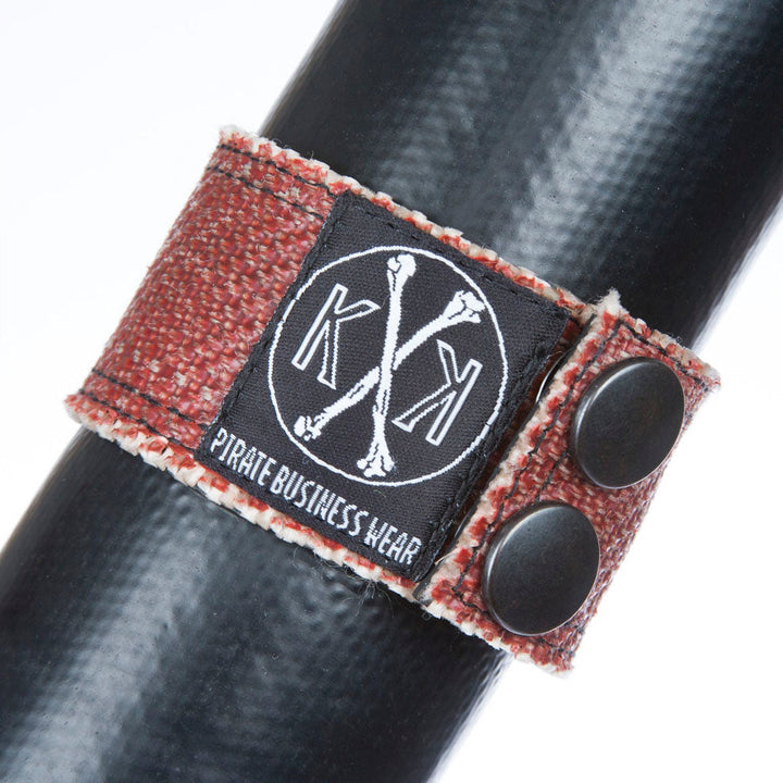 Designerarmband aus recyceltem Feuerwehrschlauch mit praktischem Druckknopfverschluss für einfaches An- und Ablegen.
